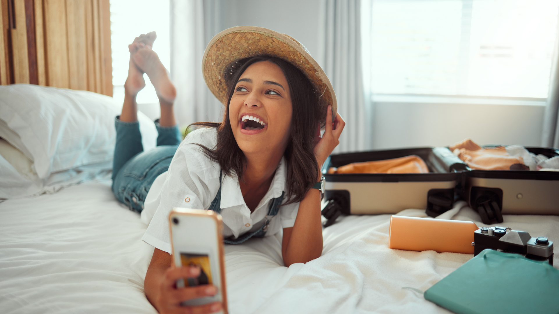 Happy Airbnb guest relaxing in a holiday rental while using a smartphone after a smooth check-in experience.